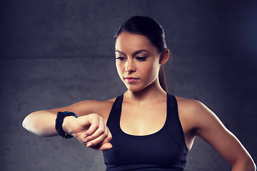 Image showing young woman with heart-rate watch in gym