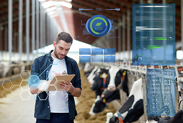 Image showing farmer with clipboard and cows in cowshed on farm