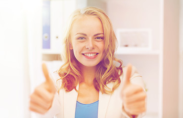 Image showing happy businesswoman showing thumbs up at office