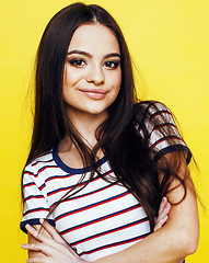 Image showing young pretty teenage woman emotional posing on yellow background, fashion lifestyle people concept 