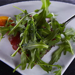 Image showing slice of prosciutto or jamon with arugula leafs