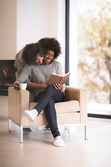 Image showing multiethnic couple hugging in front of fireplace