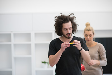 Image showing couple in party hats blowing in whistle