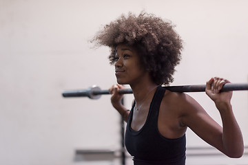 Image showing black woman lifting empty bar