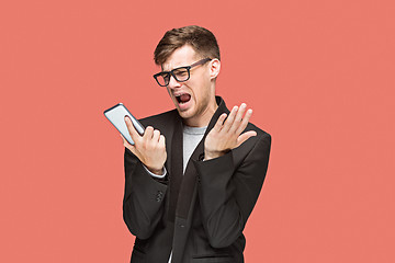 Image showing The young caucasian businessman on red background talking on cell phone