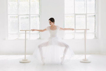 Image showing Young and incredibly beautiful ballerina is posing and dancing in a white studio