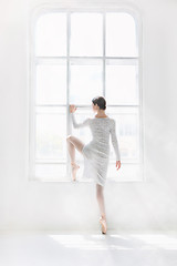 Image showing Young and incredibly beautiful ballerina is posing and dancing in a white studio