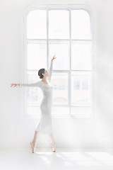 Image showing Young and incredibly beautiful ballerina is posing and dancing in a white studio