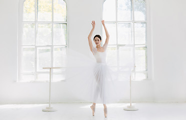 Image showing Young and incredibly beautiful ballerina is posing and dancing in a white studio