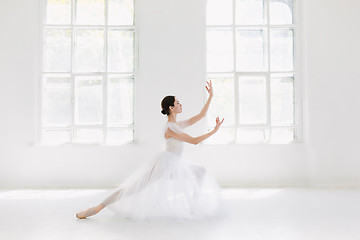 Image showing Young and incredibly beautiful ballerina is posing and dancing in a white studio