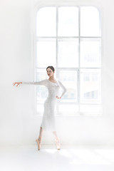 Image showing Young and incredibly beautiful ballerina is posing and dancing in a white studio