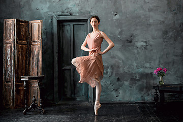 Image showing Young and incredibly beautiful ballerina is posing and dancing in a black studio