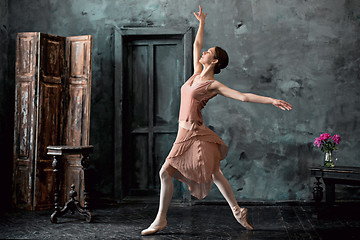 Image showing Young and incredibly beautiful ballerina is posing and dancing in a black studio