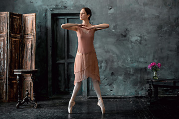 Image showing Young and incredibly beautiful ballerina is posing and dancing in a black studio