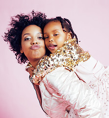 Image showing young pretty african-american mother with little cute daughter hugging, happy smiling on pink background, lifestyle modern people concept 