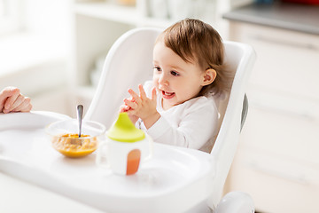 Image showing happy baby girl with food and drink eating at home