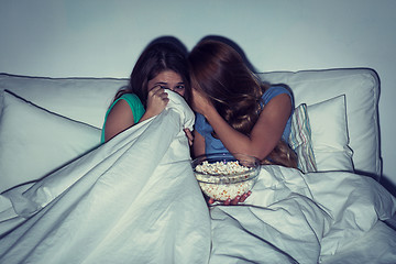 Image showing scared teenage girls watching horror on tv at home