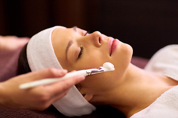 Image showing beautician applying facial mask to woman at spa