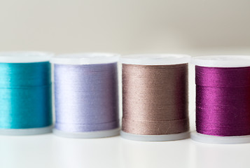 Image showing row of colorful thread spools on table