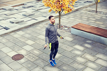 Image showing man exercising with jump-rope outdoors