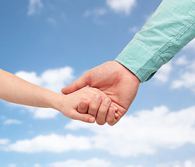 Image showing father and child holding hands over blue sky