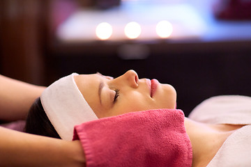 Image showing woman having face massage with terry gloves at spa