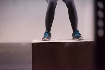 Image showing black woman is performing box jumps at gym