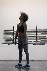 Image showing black woman lifting empty bar