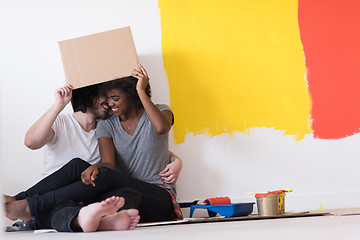 Image showing young multiethnic couple playing with cardboard boxes