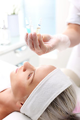 Image showing Vitamin cocktail in an ampoule, a woman in the beauty salon
