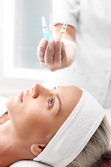 Image showing Hand beauticians shows an ampoule with a cosmetic preparation