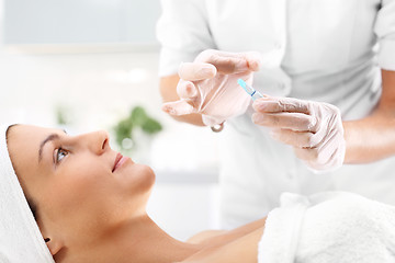 Image showing Hand beauticians shows an ampoule with a cosmetic preparation