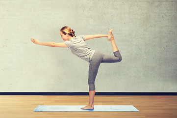 Image showing woman making yoga in lord of the dance pose on mat