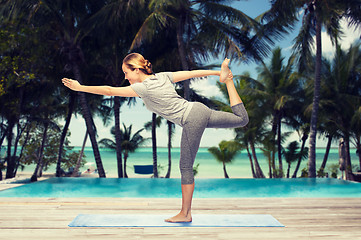 Image showing woman making yoga in lord of the dance pose on mat