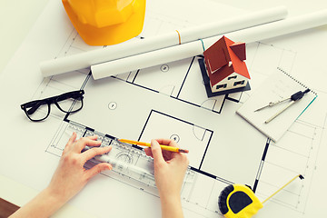 Image showing close up of hands with ruler measuring blueprint