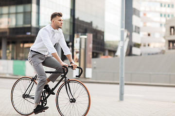 Image showing man with headphones riding bicycle on city street