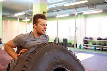 Image showing man doing strongman tire flip training in gym