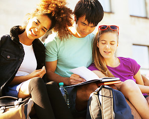 Image showing cute group of teenages at the building of university with books 