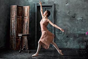 Image showing Young and incredibly beautiful ballerina is posing and dancing in a black studio