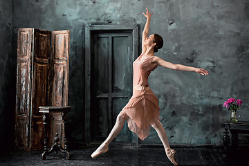 Image showing Young and incredibly beautiful ballerina is posing and dancing in a black studio