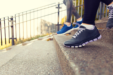 Image showing close up of feet running downstairs in city