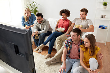 Image showing happy friends with popcorn watching tv at home