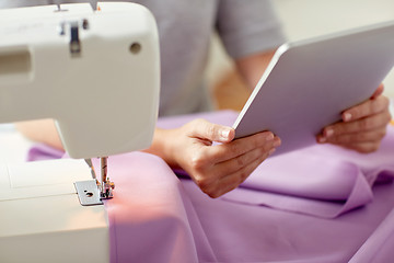 Image showing tailor with sewing machine, tablet pc and fabric