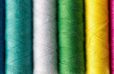 Image showing row of colorful thread spools on table