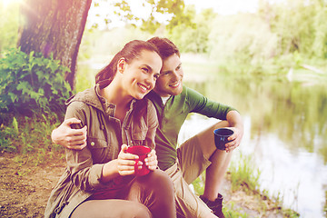 Image showing happy couple with cups drinking in nature