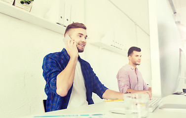 Image showing happy creative man calling on cellphone at office