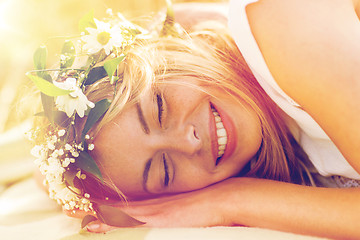 Image showing happy woman in wreath of flowers lying