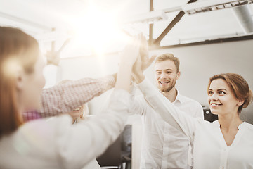 Image showing happy business team making high five at office