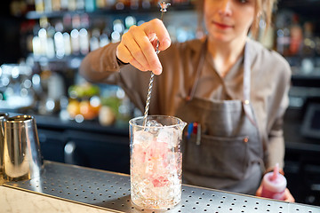 Image showing bartender with cocktail stirrer and glass at bar