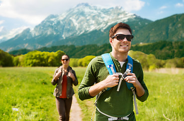 Image showing happy couple with backpacks hiking outdoors